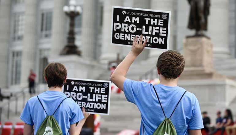 Students hold up anti-abortion signs at the Midwest March for Life (Photo by Anna Spoerre - Missouri Independent)