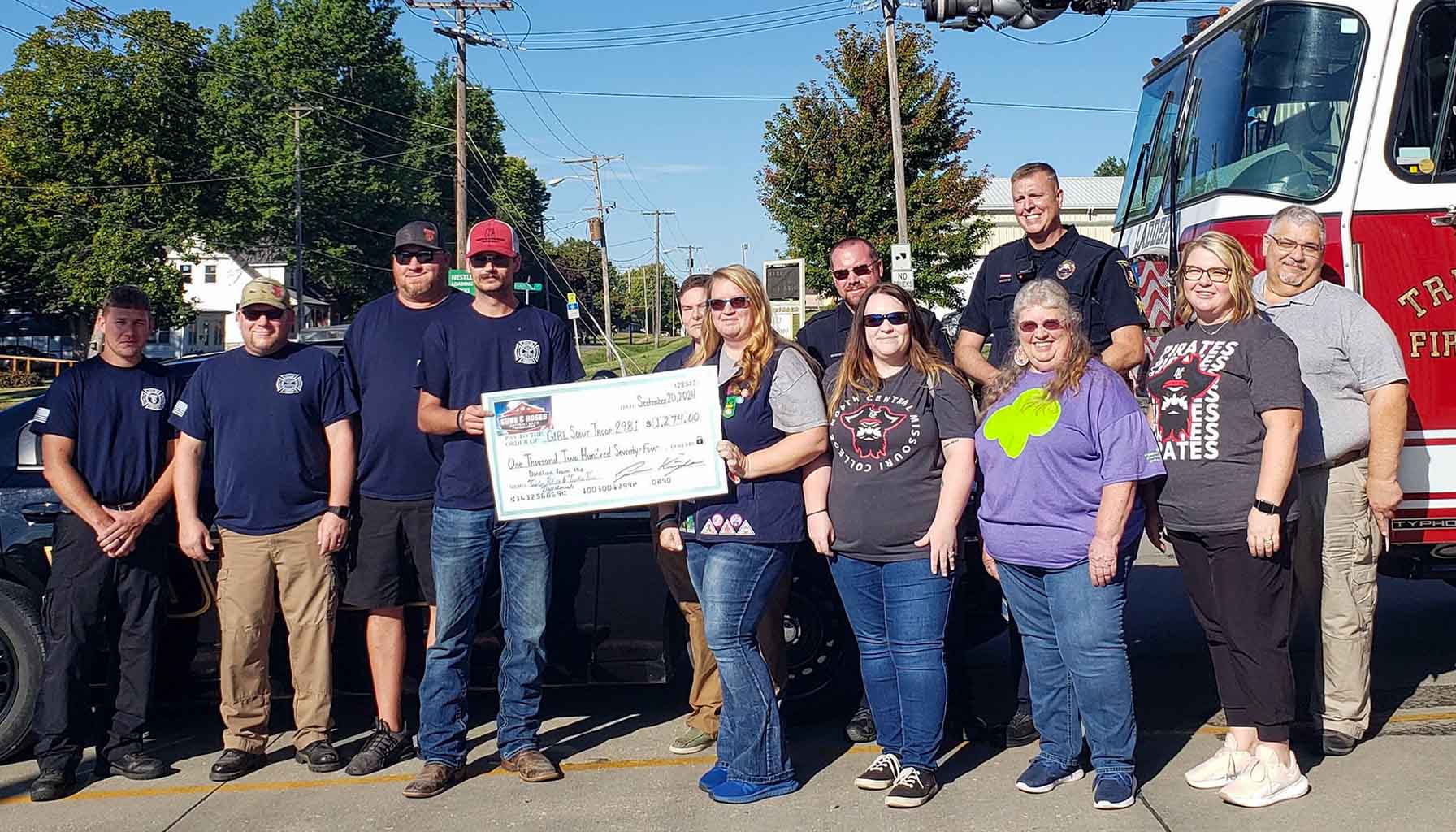 Trenton Fire and Police present check to girl scouts guns and hoses 2024